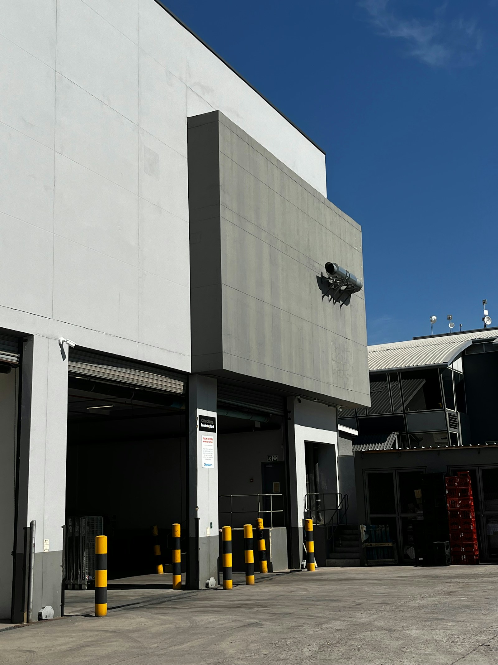 Modern industrial building exterior with loading docks under a clear sky